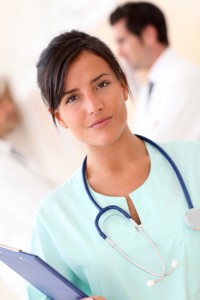 Beautiful nurse standing with medical people